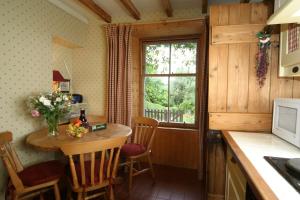 StrachurSpringburn Cottage的厨房配有小桌子和窗户。
