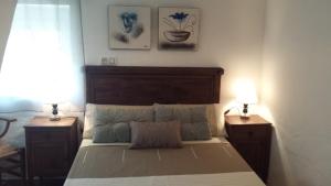 卡索拉Alojamiento rural La Casilla的一间卧室配有一张带2个床头柜和2盏灯的床。