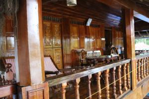 阿勒皮Malayalam Lake Resort的木墙房间的一排椅子