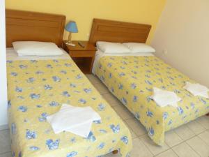 加利萨斯Peter & Tony Rooms的两张位于酒店客房的床,花朵蓝色