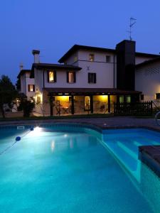 GruaroCa' Dei Molini的夜间在房子前面的游泳池