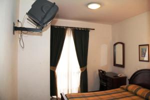 圣克鲁斯Residencial Santo António的一间卧室设有一张床和一个带电视的窗户。