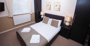尚克林Somerton Lodge的卧室配有一张带白色床单和枕头的大床。