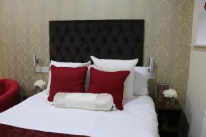 布特尔特里维利斯塞福思酒店的一张带红色和白色枕头的床