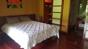 TaravaoVilla ManaOra的客房内的一张带白色棉被的床