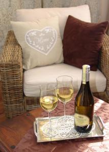 特希尔加尔尼兰德豪斯乌图姆酒店的桌子上放有一瓶葡萄酒和两杯酒