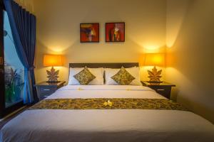 乌鲁瓦图巴厘岛海滩丽嘉别墅的一间卧室配有一张大床和两盏灯
