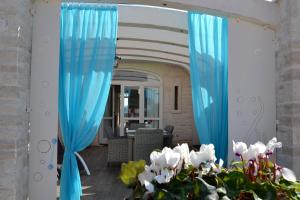 滨海波利尼亚诺Casale Porto Contessa的客厅里一对蓝色窗帘