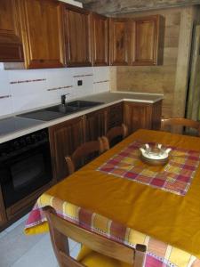 艾马维尔Appartamento Le Jardin CIR VDA Aymavilles 0009的带木桌的厨房和带桌布的厨房