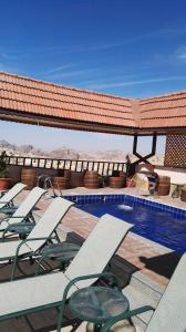 瓦迪穆萨夸特洛瑞莱克斯酒店的连排躺椅和一个游泳池