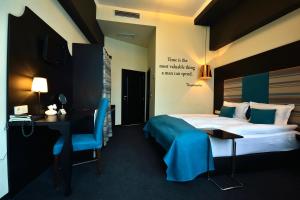鲁塞城市艺术精品酒店的酒店客房配有一张床、一张书桌和一张书桌。