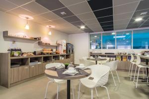 图尔Nemea Appart Hotel Quai Victor Tours Centre的一间带2张桌子和椅子的餐厅以及一间厨房