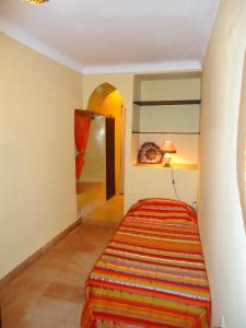 马拉喀什Riad Aldiana的一间铺有色彩缤纷地毯的床铺客房
