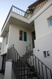 首尔弘大兹浦旅馆 的白色的房子,设有楼梯和阳台