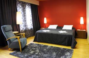 Kankaanpää卢米埃恩芬兰迪亚酒店的一间卧室配有一张床、一把椅子和红色的墙壁
