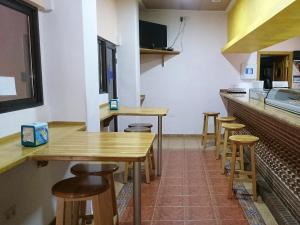 瓜达拉哈拉圣马科斯2号旅馆的餐厅内的厨房配有木桌和凳子