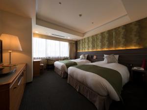 熊本熊本KKR酒店的酒店客房设有两张床和窗户。