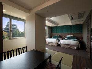 熊本熊本KKR酒店的一间酒店客房,配有两张床和一张餐桌