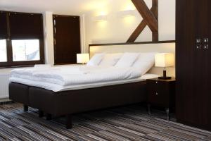 波兹南城市中心艾莉芬特之家酒店的一张大床,位于带两盏灯的房间
