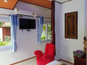 Khun Han雷拉瓦迪度假村的客厅配有红色椅子和平面电视