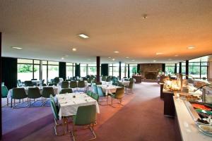 特威泽尔Distinction Mackenzie Country Hotel的用餐室设有桌椅和窗户。