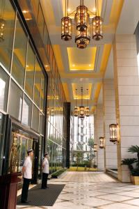 上海上海大酒店 的站在大楼前厅的两个人