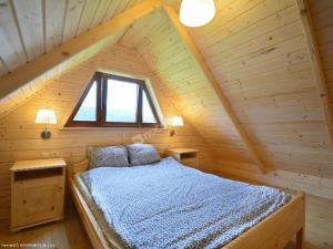 GrywałdDomki Czterech Braci的木制阁楼卧室配有一张床