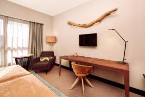 莱昂Barceló León Conde Luna的酒店客房设有一张桌子、一台电视和一张床