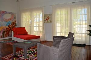 棕榈滩鹦鹉别墅酒店的客厅配有两把椅子和红椅