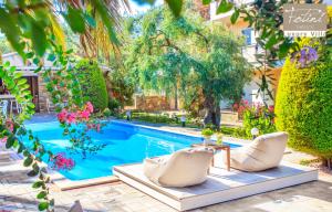 萨索斯Luxury Villa Fotini的一个带两把白色椅子和桌子的游泳池
