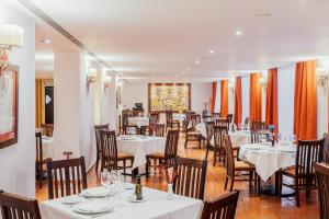 曼萨纳雷斯曼萨纳雷斯旅馆的一间设有白色桌椅的用餐室