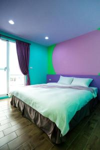 南湾南景天民宿的一间卧室设有一张大床,拥有紫色和绿色的墙壁