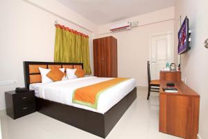 德瓦纳哈利-班加罗尔Arra Grande Suites - Nearest Airport Hotels Bangalore的一间卧室配有一张床、一张书桌和一台电视