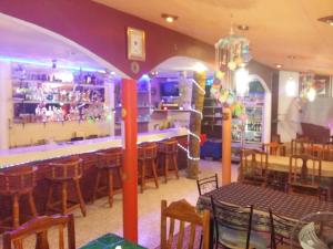 Khun Han雷拉瓦迪度假村的餐厅设有酒吧,配有桌椅