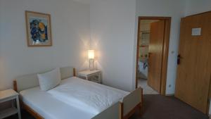 Bubenreuth浪翰墨尔旅馆的卧室配有带灯和门的白色床