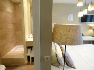 布鲁日阿莱格里亚酒店的一间卧室配有带灯的床和一间浴室