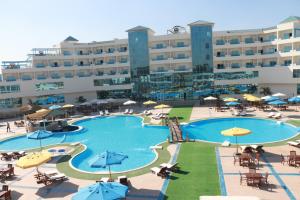 开罗卫队酒店的酒店设有带桌子和遮阳伞的大型游泳池