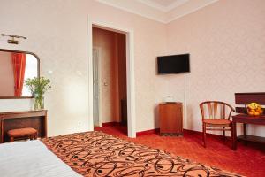 巴拉顿菲赖德阿斯托利亚酒店的酒店客房配有一张床、一张书桌和一台电视。
