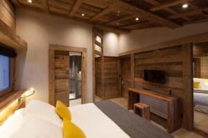 梅杰夫欧克英德福酒店的一间带木墙的卧室、一张床和电视