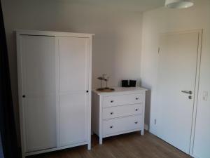 兰肯-格拉尼茨Das Rügenhaus的卧室配有白色橱柜和梳妆台