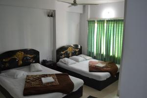 库克斯巴扎Hotel Shams Plaza的一间卧室设有两张床和绿帘