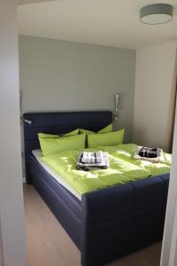 奥斯赛拜-塞林Ostseezauber的一间卧室配有一张带绿床单和枕头的床。