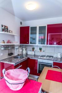 奥西耶克Apartment Flores的厨房配有红色橱柜和木桌