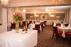 Templeglantine德文酒店的宴会厅配有白色的桌椅和鲜花