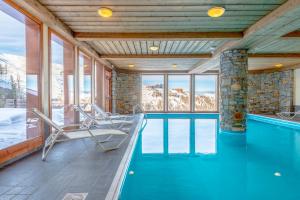 拉普拉涅拉格朗日阿斯公寓式酒店的一座带椅子的游泳池,位于一座带山脉的房子里