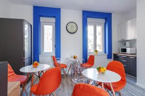 扎达尔Sky Hostel的厨房配有2张桌子和橙色椅子