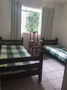 康赛瓦托利亚Casas de Temporada Conservatória的两张床位于带窗户的房间内