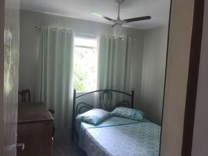 康赛瓦托利亚Casas de Temporada Conservatória的一间卧室配有一张带吊扇和窗户的床。