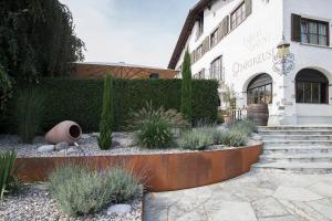图恩Italian Lifestyle Hotel & Osteria Chartreuse的一座建筑,前面有一个种有植物的花园