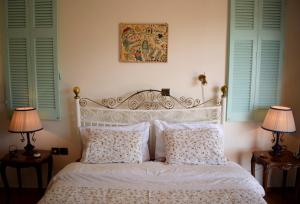 雅典全景顶层公寓的一间卧室配有一张带两盏灯的床和两扇窗户。